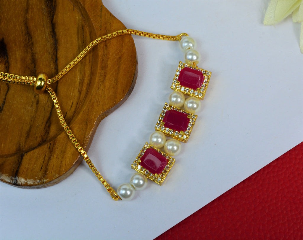 Jewelopia Ruby Diamond Studded Gold Plated With Pearl Rakhi Bracelet Adjustable for Women and Girls